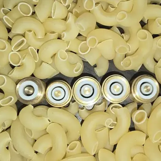 Five R.N. PTFE-lined brass macaroni inserts lined up among elbow macaroni
